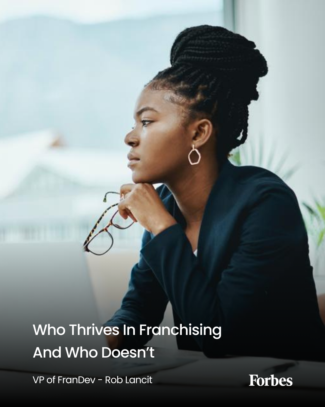 Young businesswoman using a laptop in a modern office, representing franchising success and entrepreneurship with Stratus Building Solutions.